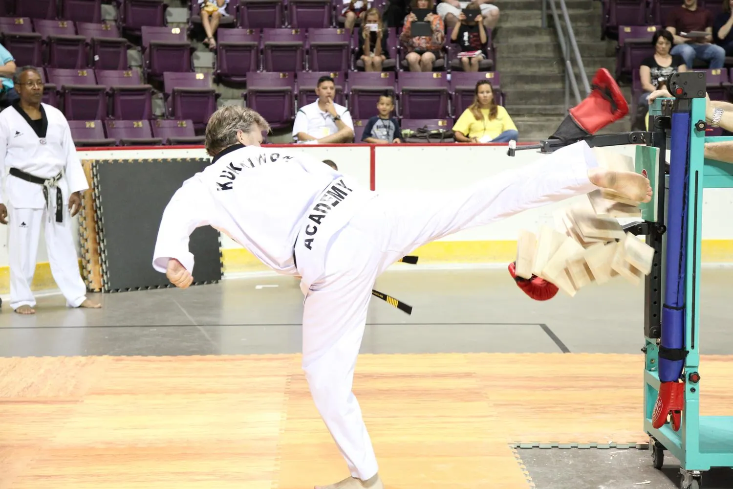 A Stevens World Taekwondo student throwing a roundhouse kick at a competition